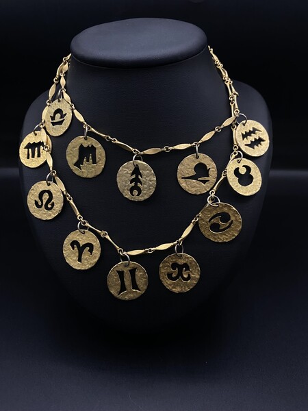 Necklace by Paco Rabanne in brushed gold metal  double row   representing the 12 astrological signs 