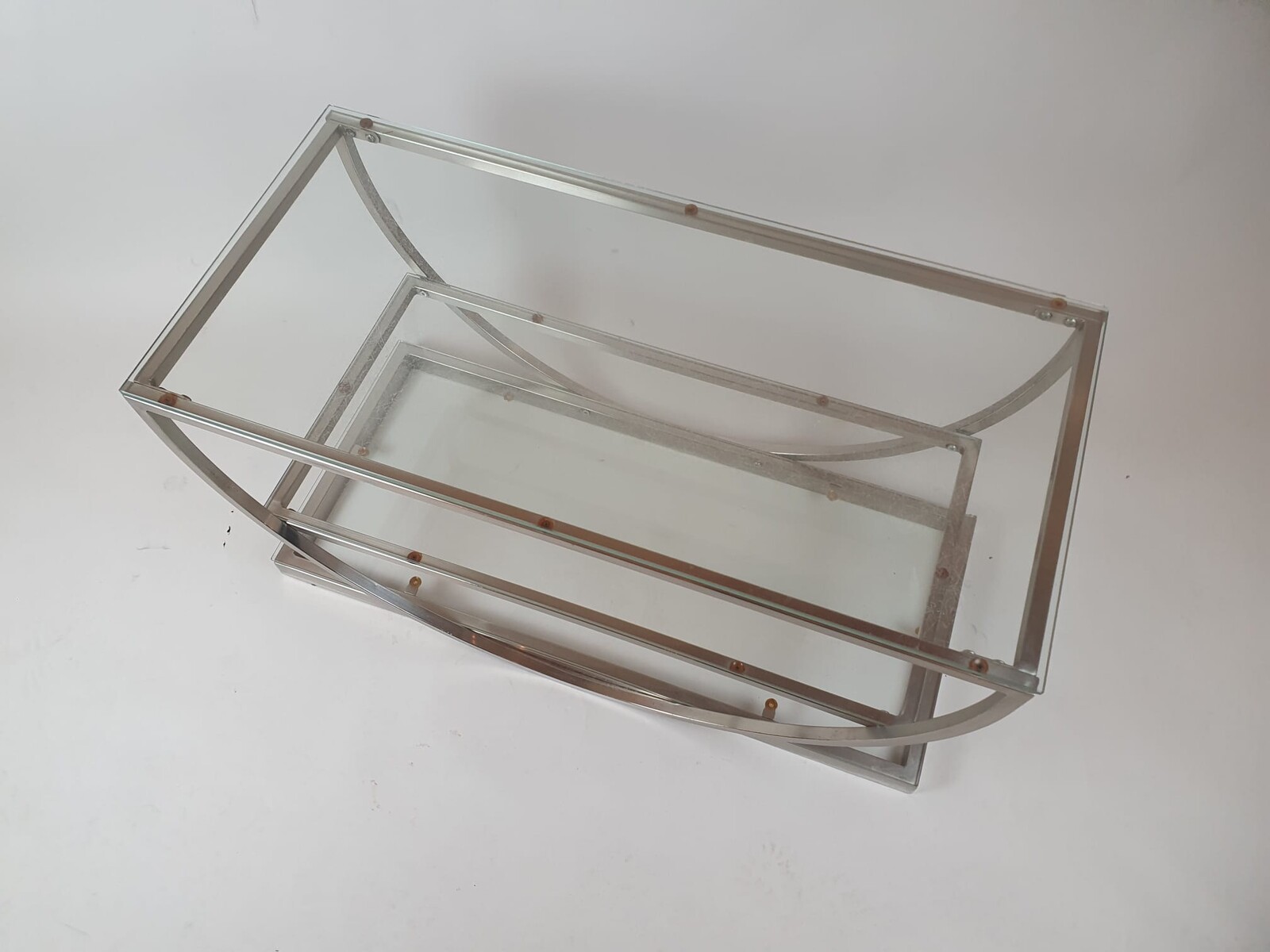 Brushed steel coffee table with glass shelves, circa 1970