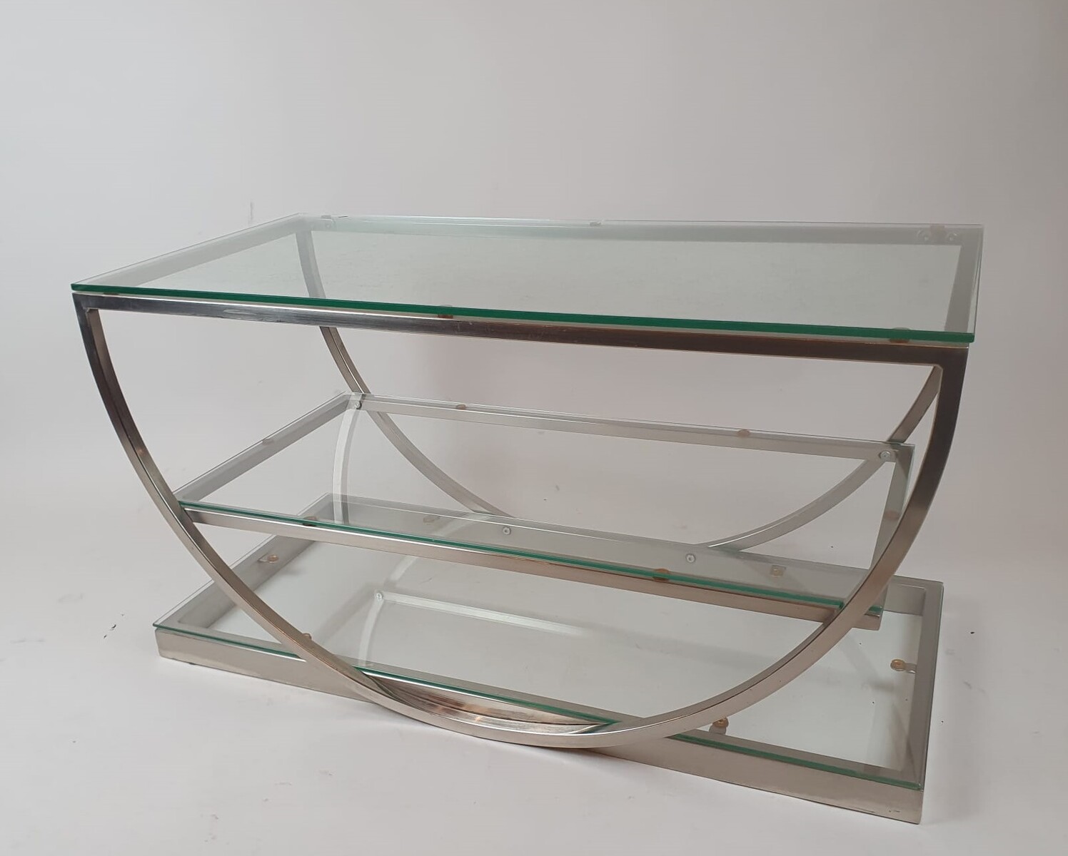 Brushed steel coffee table with glass shelves, circa 1970