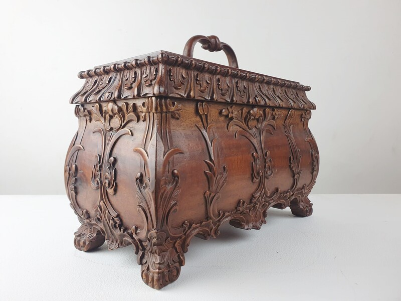 Finely carved wooden box releasing a small tray and compartments.