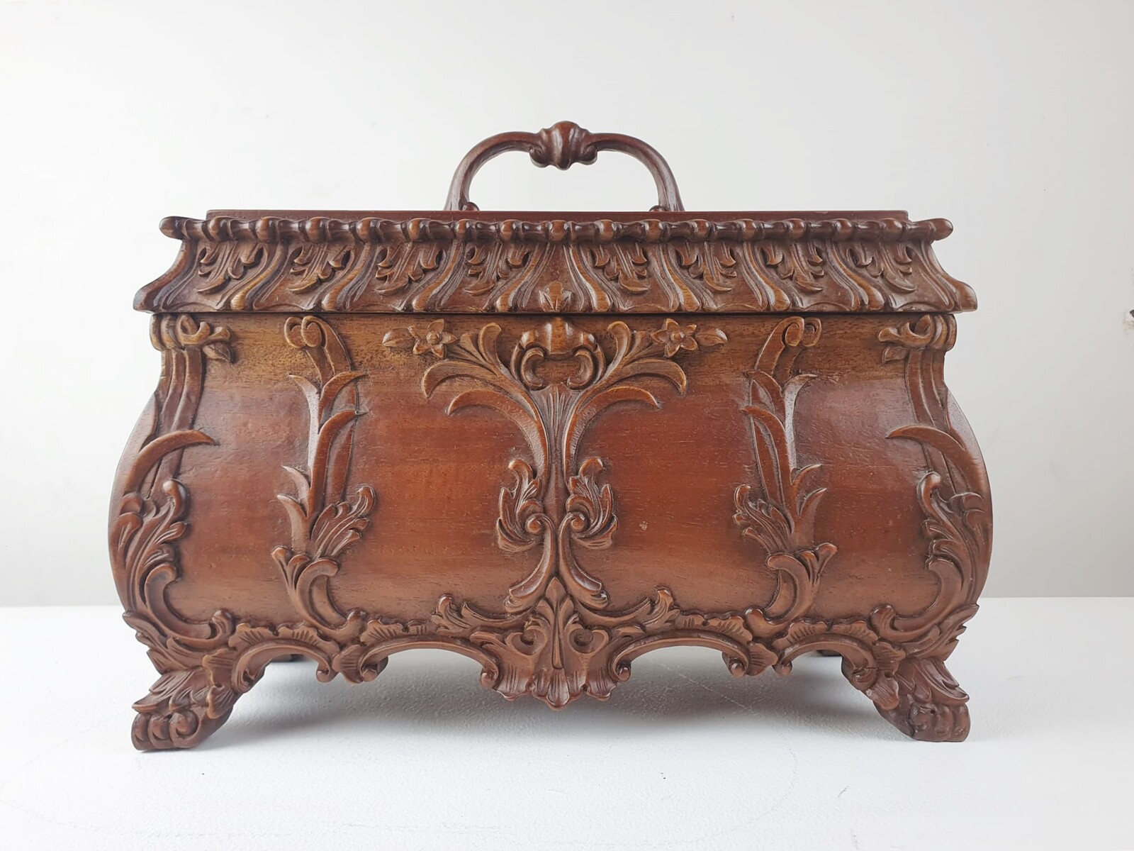 Finely carved wooden box releasing a small tray and compartments.
