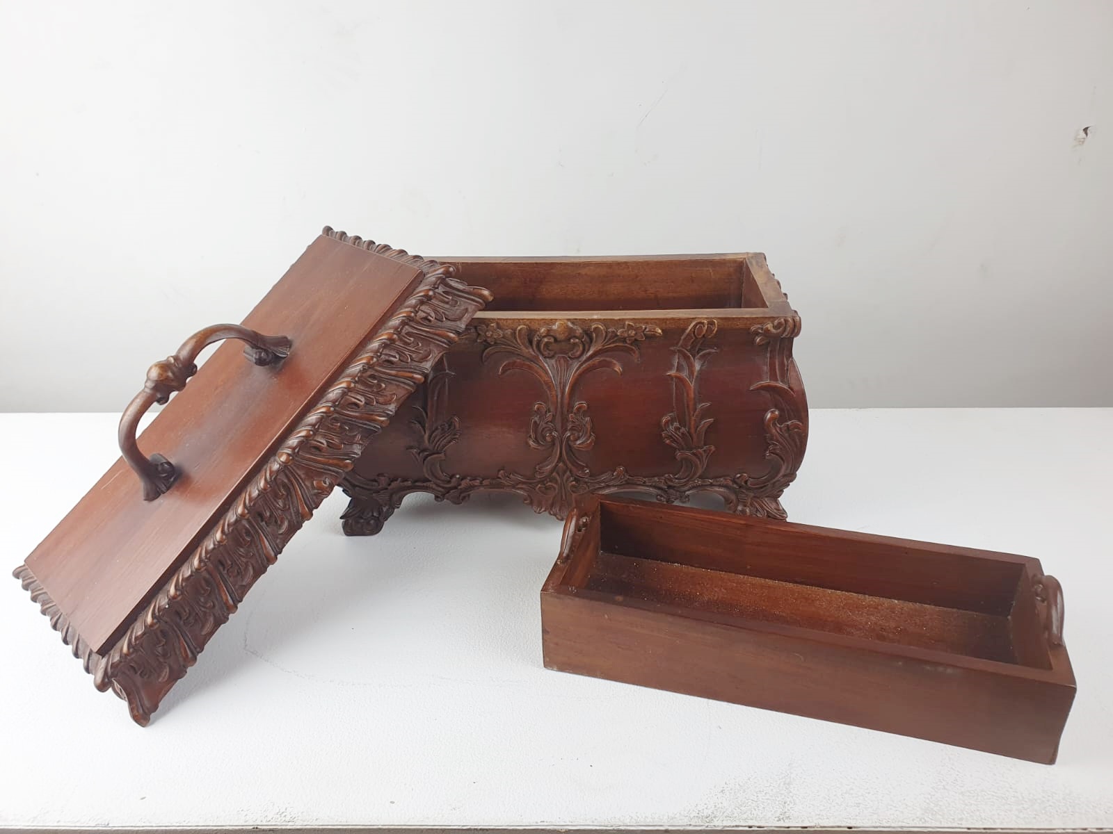 Finely carved wooden box releasing a small tray and compartments.