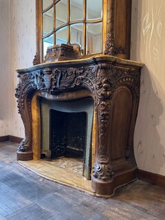 Impressive fireplace and its richly carved wooden trumeau highlighted with yellow Siena marble, circa 1900