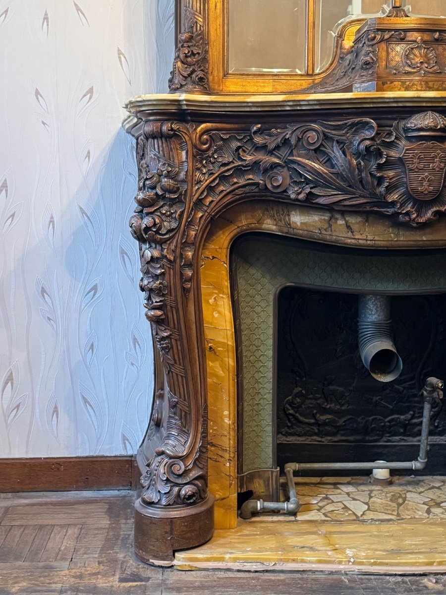 Impressive fireplace and its richly carved wooden trumeau highlighted with yellow Siena marble, circa 1900