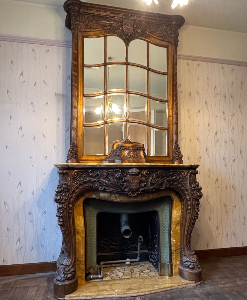 Impressive fireplace and its richly carved wooden trumeau highlighted with yellow Siena marble, circa 1900