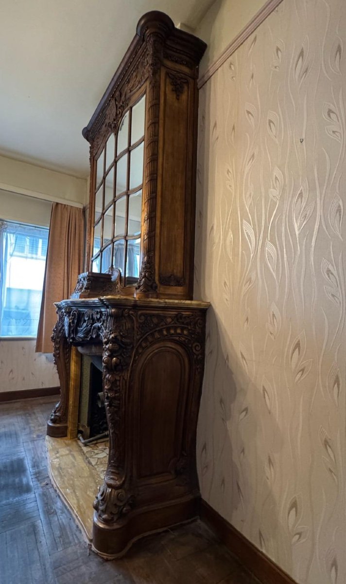 Impressive fireplace and its richly carved wooden trumeau highlighted with yellow Siena marble, circa 1900