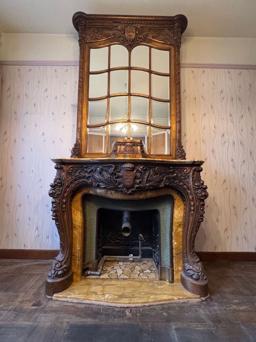 Impressive fireplace and its richly carved wooden trumeau highlighted with yellow Siena marble, circa 1900