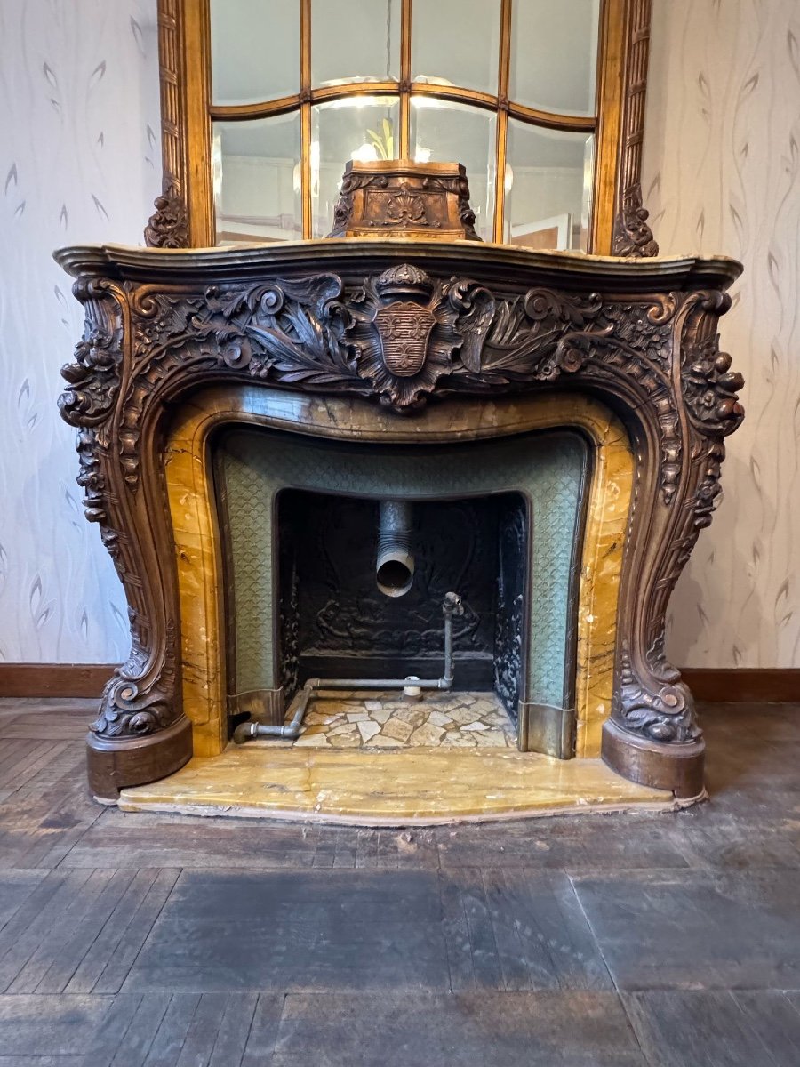 Impressive fireplace and its richly carved wooden trumeau highlighted with yellow Siena marble, circa 1900