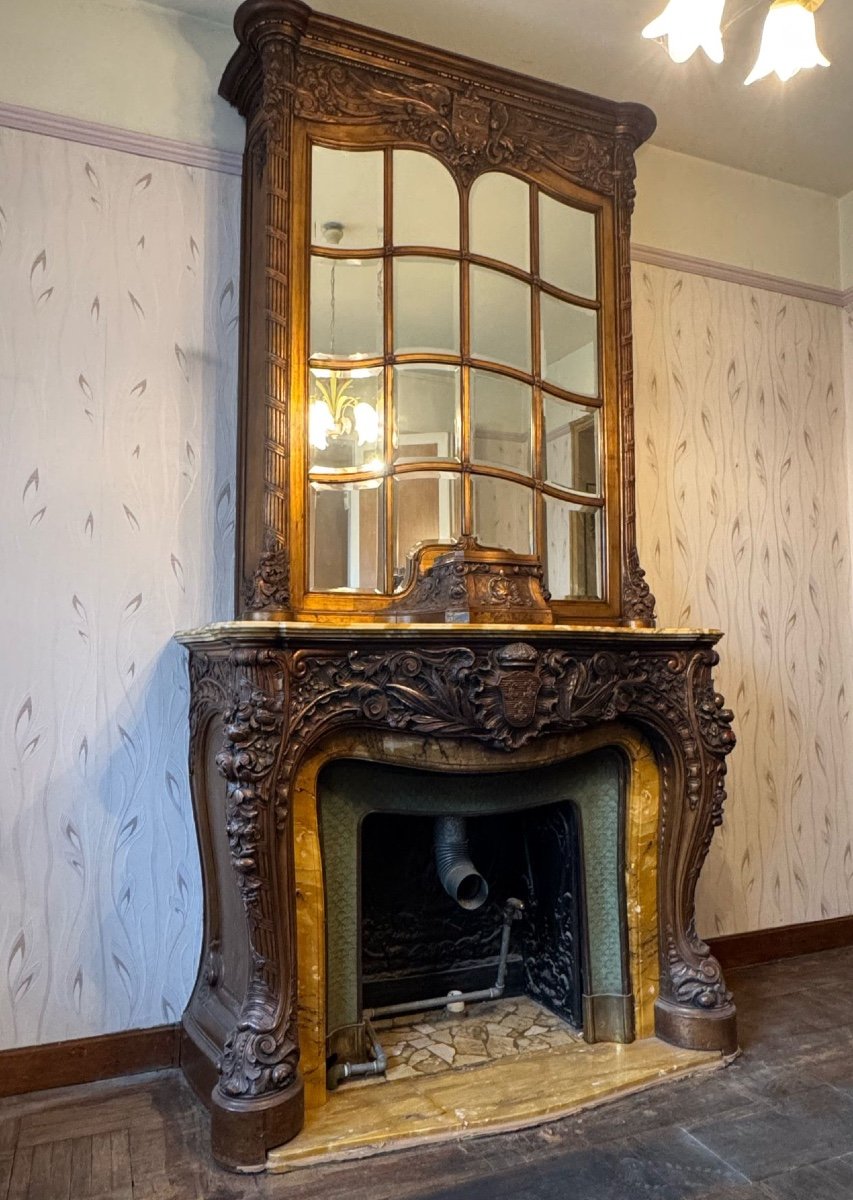 Impressive fireplace and its richly carved wooden trumeau highlighted with yellow Siena marble, circa 1900