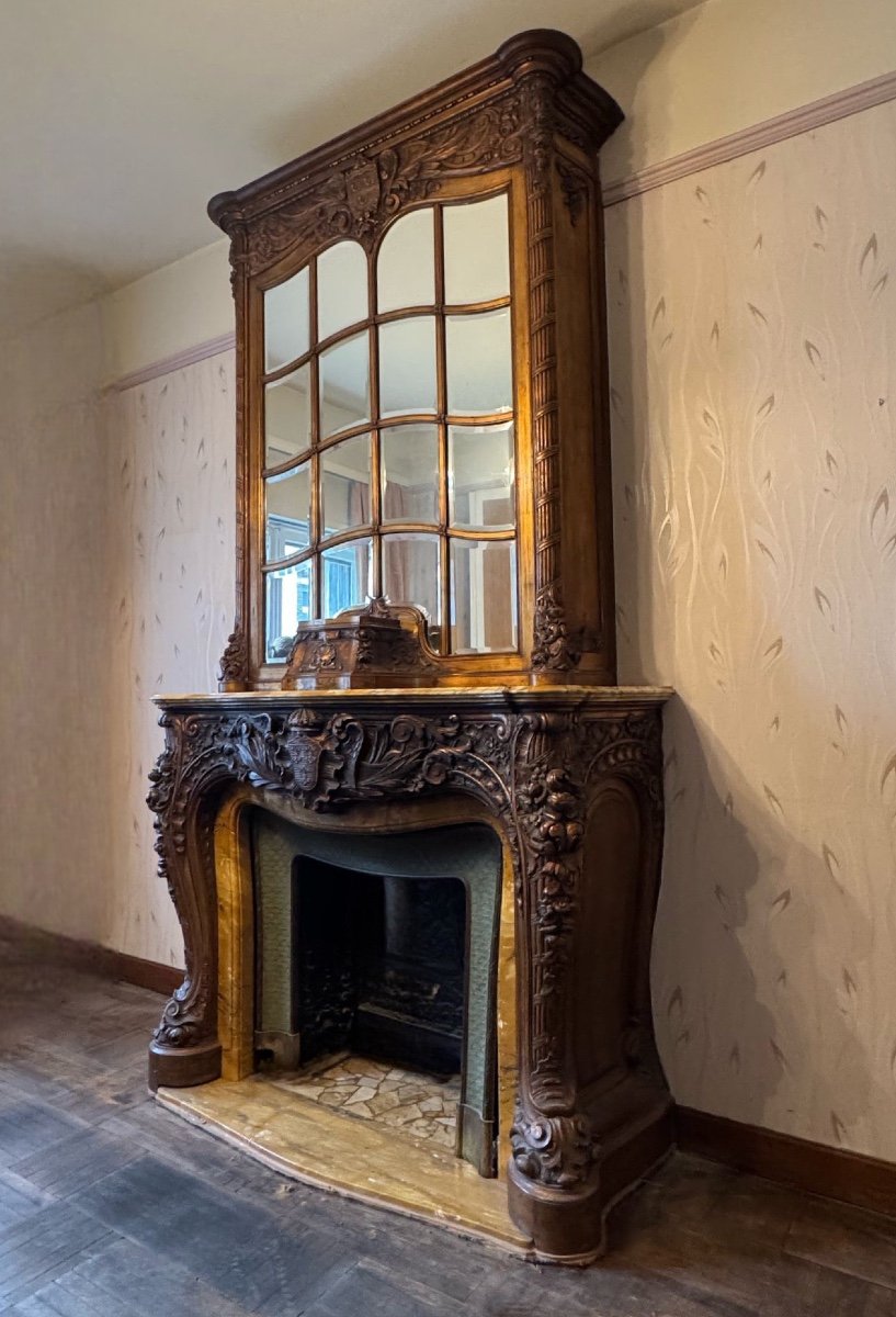 Impressive fireplace and its richly carved wooden trumeau highlighted with yellow Siena marble, circa 1900