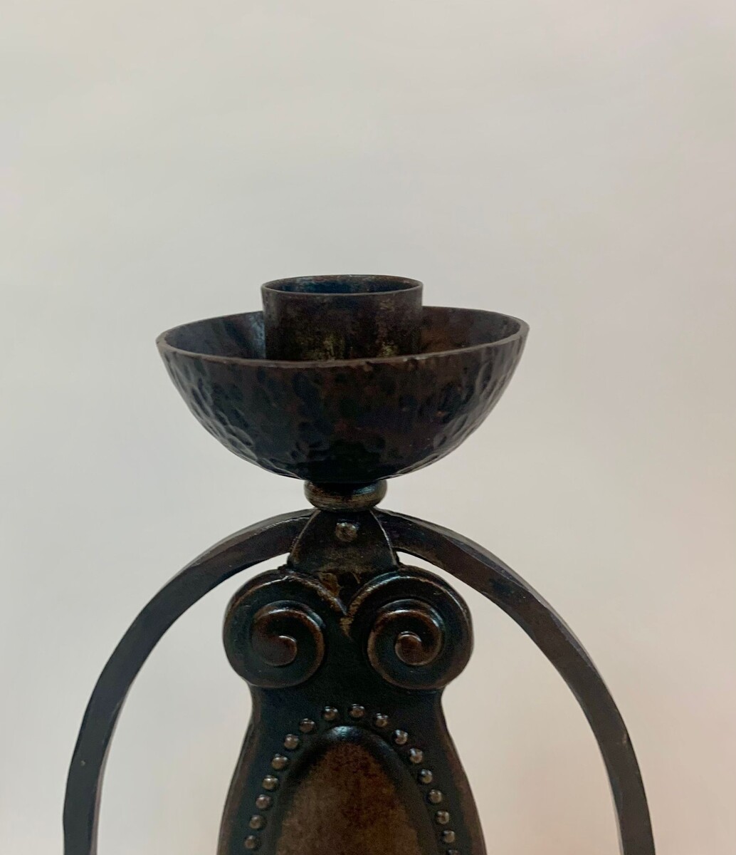 Pair of arts and crafts candlesticks in wrought and hammered iron