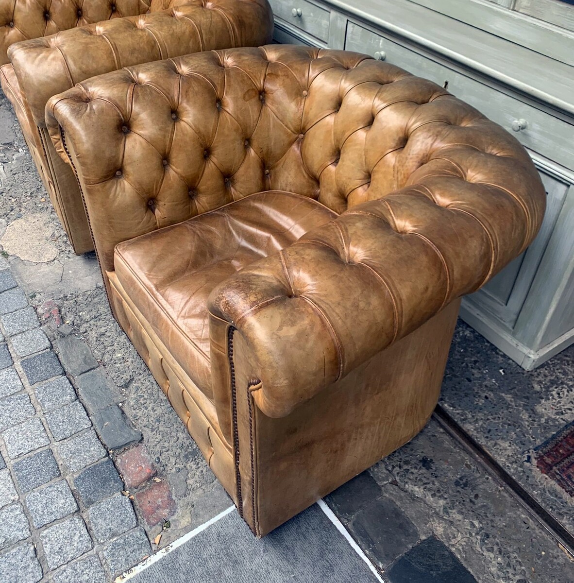 Pair of caramel-colored chesterfield armchairs