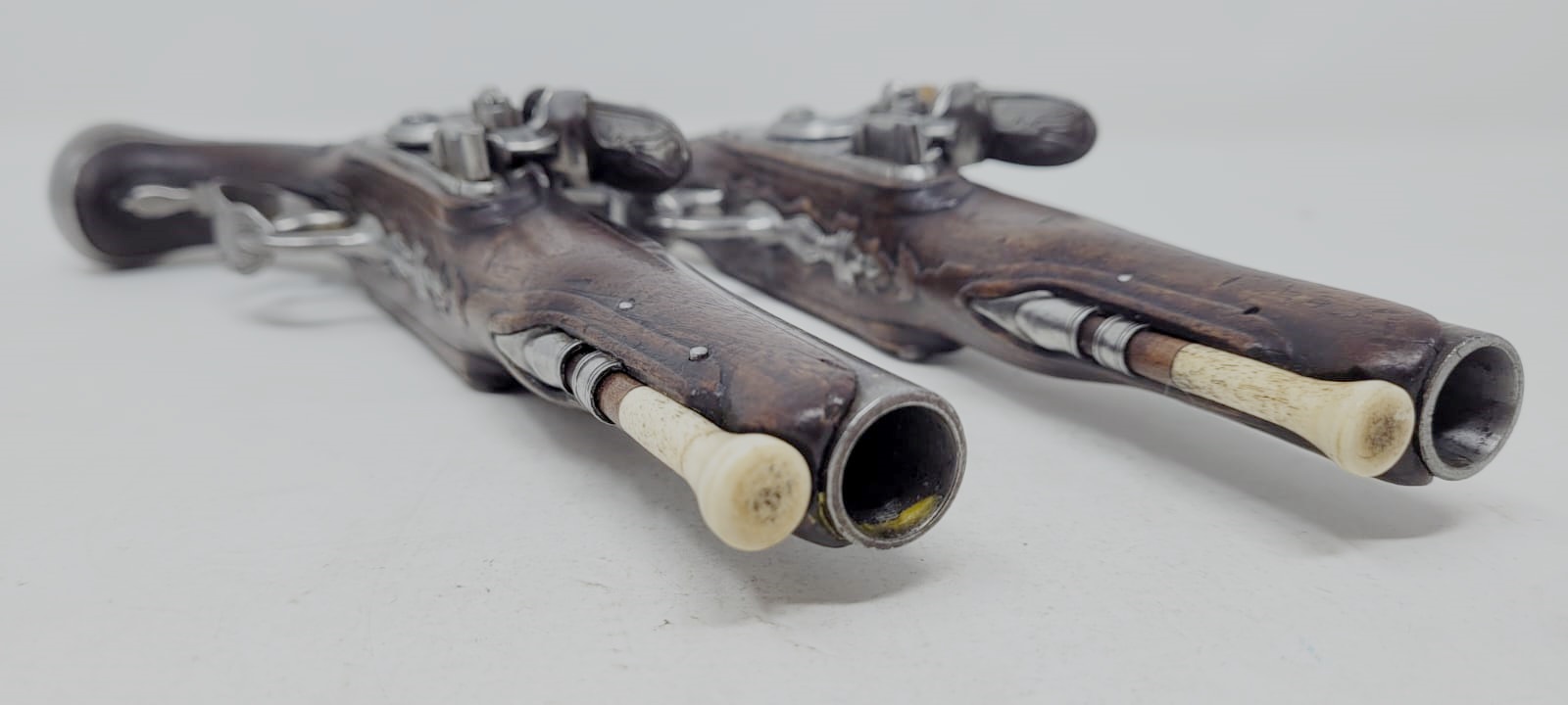 pair of civil flintlock pistols - iron mount with fine chiseling - signed and localized lock - barrel with large traces of gold decoration - carved wood at the thumb piece level - France +/- 1730 - perfect mechanical condition