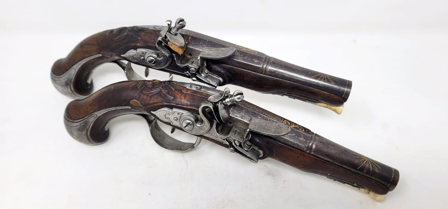 pair of civil flintlock pistols - iron mount with fine chiseling - signed and localized lock - barrel with large traces of gold decoration - carved wood at the thumb piece level - France +/- 1730 - perfect mechanical condition