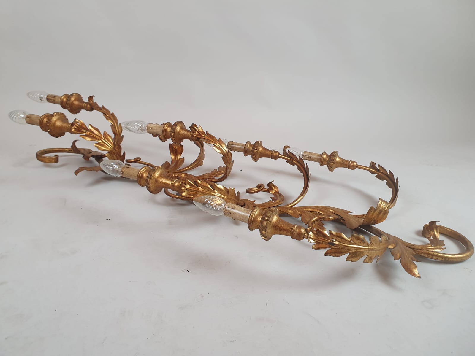 Pair of large wrought iron and gilded sheet metal wall lights, circa 1960 (Tainted patina on one of them)