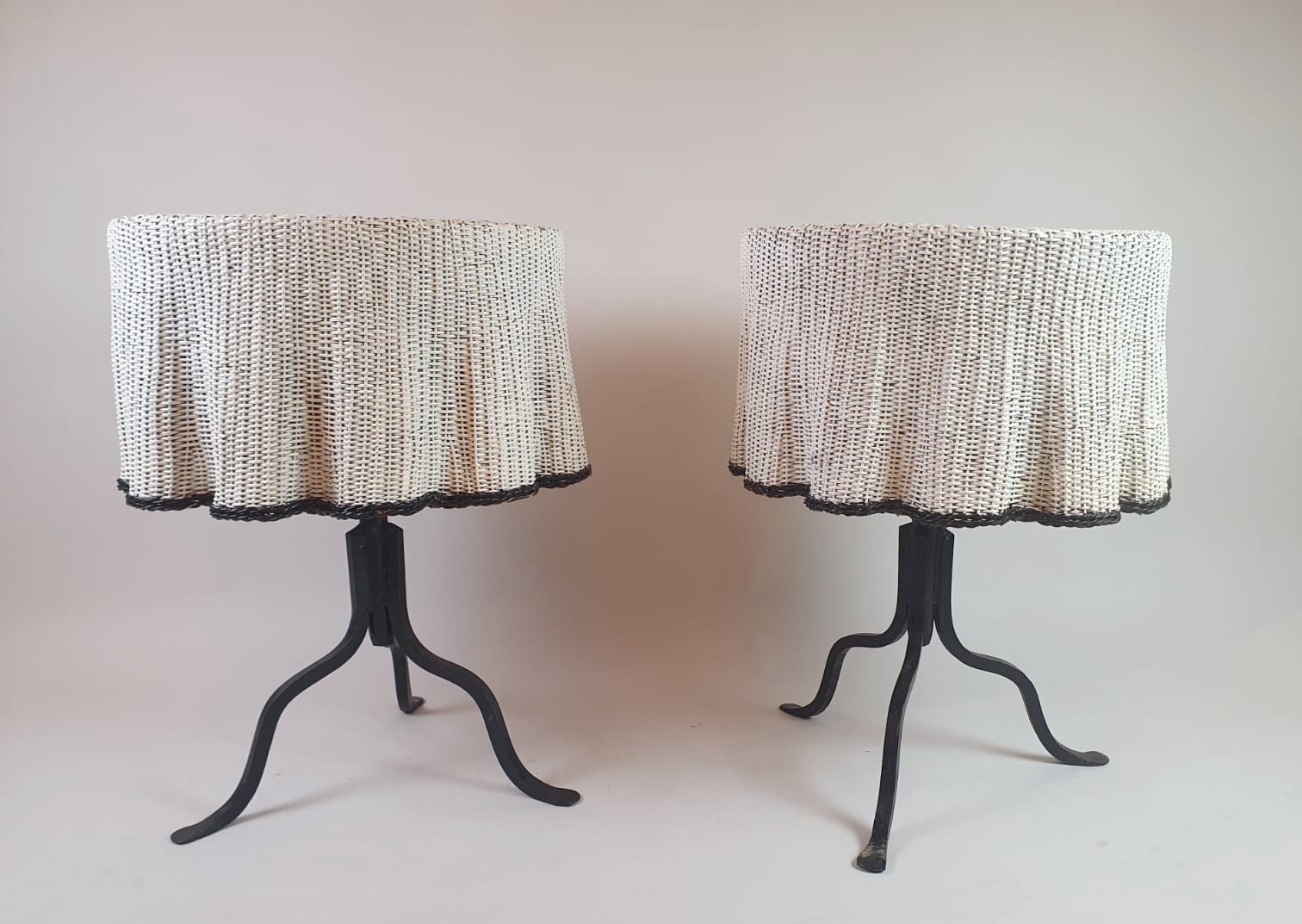 Pair of side tables, wrought iron base and wicker shelf imitating a drape