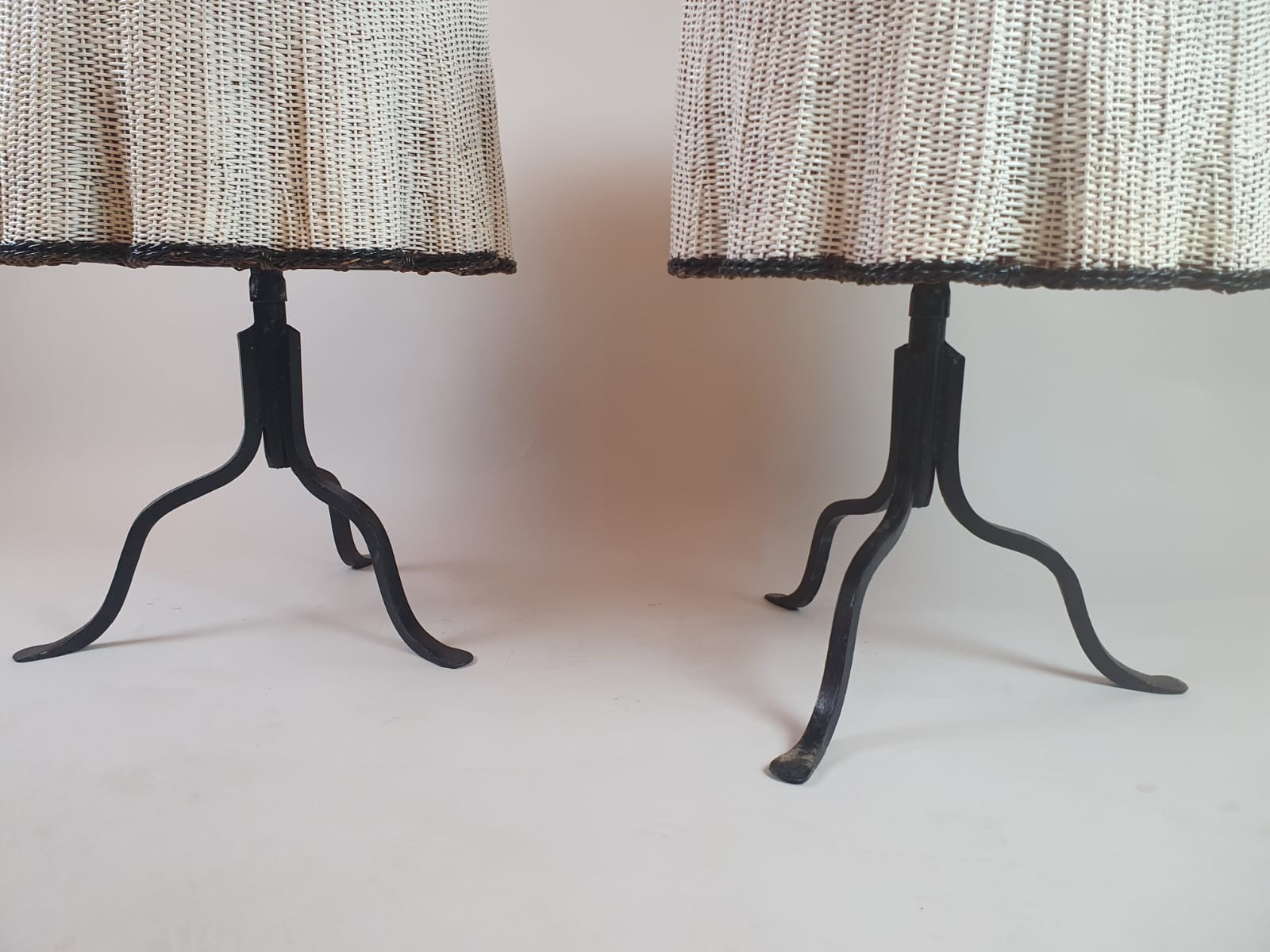 Pair of side tables, wrought iron base and wicker shelf imitating a drape