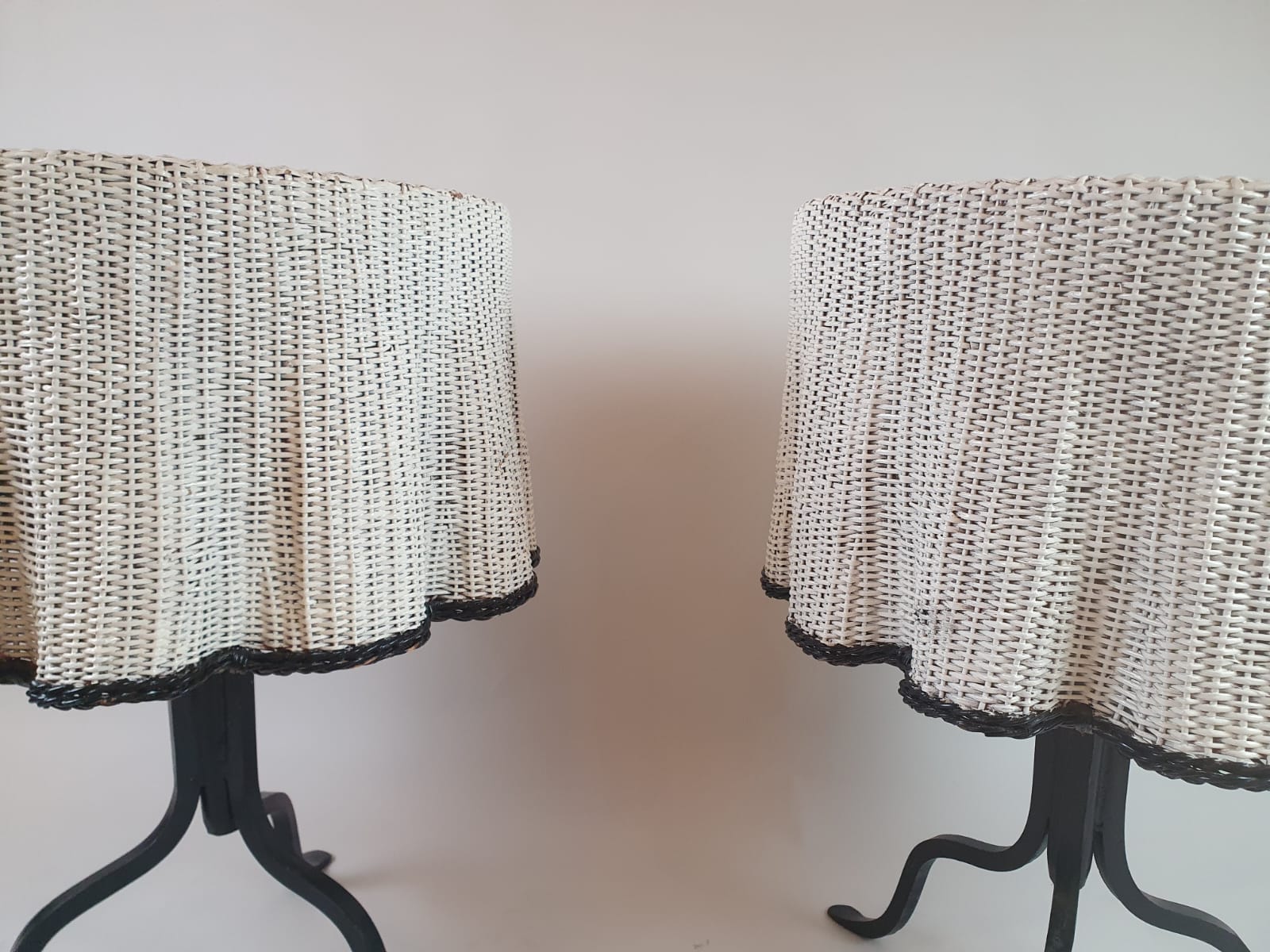 Pair of side tables, wrought iron base and wicker shelf imitating a drape