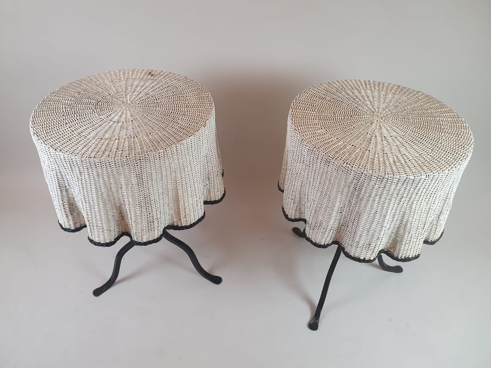 Pair of side tables, wrought iron base and wicker shelf imitating a drape